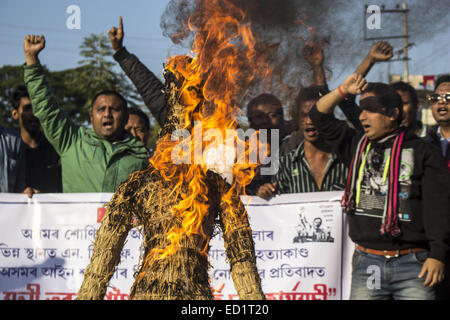 Sivasagar, Assam, Indien. 24. Dezember 2014. Indien, SIVASAGAR: Aktivisten der Asom Jatiyatabadi Yuba Charta Parishad (AJYCP) brennen das Bildnis von Assam Ministerpräsident Tarun Gogoi aus Protest gegen Angriffe auf die Dorfbewohner von militanten an vier verschiedenen Orten im Sivasagar Viertel der nordöstliche Assam Zustand am 24. Dezember 2014. Stockfoto