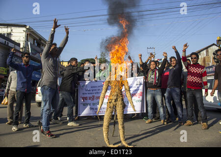 Sivasagar, Assam, Indien. 24. Dezember 2014. Indien, SIVASAGAR: Aktivisten der Asom Jatiyatabadi Yuba Charta Parishad (AJYCP) brennen das Bildnis von Assam Ministerpräsident Tarun Gogoi aus Protest gegen Angriffe auf die Dorfbewohner von militanten an vier verschiedenen Orten im Sivasagar Viertel der nordöstliche Assam Zustand am 24. Dezember 2014. Stockfoto