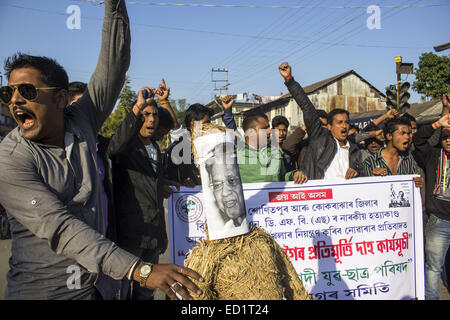 Sivasagar, Assam, Indien. 24. Dezember 2014. Indien, SIVASAGAR: Aktivisten der Asom Jatiyatabadi Yuba Charta Parishad (AJYCP) brennen das Bildnis von Assam Ministerpräsident Tarun Gogoi aus Protest gegen Angriffe auf die Dorfbewohner von militanten an vier verschiedenen Orten im Sivasagar Viertel der nordöstliche Assam Zustand am 24. Dezember 2014. Stockfoto