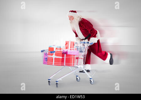 Zusammengesetztes Bild von Santa schieben eines Einkaufswagens Stockfoto
