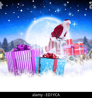 Zusammengesetztes Bild von Santa schiebt einen Einkaufswagen Stockfoto