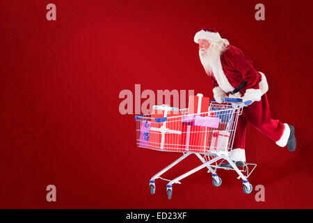 Zusammengesetztes Bild von Santa schiebt einen Einkaufswagen Stockfoto