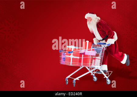 Zusammengesetztes Bild von Santa schiebt einen Einkaufswagen Stockfoto