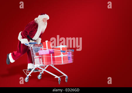 Zusammengesetztes Bild von Santa schiebt einen Einkaufswagen Stockfoto