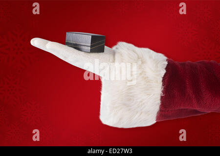 Zusammengesetztes Bild Santas Hand zeigt eine kleine box Stockfoto