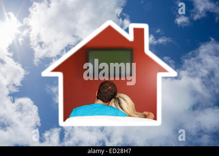 Zusammengesetztes Bild des Paares sitzen auf der Couch vor dem Fernseher zu Hause Stockfoto
