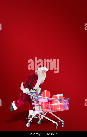 Zusammengesetztes Bild von Santa schiebt einen Einkaufswagen Stockfoto
