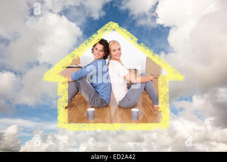 Zusammengesetztes Bild des Paares auf dem Boden sitzend Stockfoto