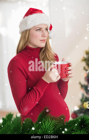 Zusammengesetztes Bild festliche schwanger Frau mit Becher stehend Stockfoto