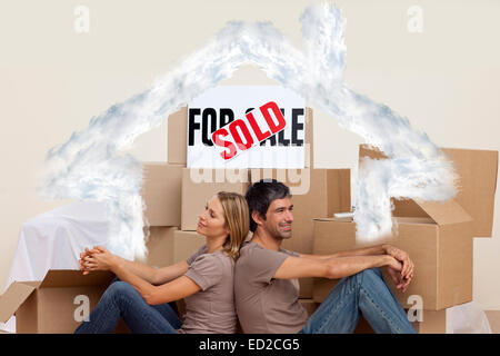 Zusammengesetztes Bild von glücklichen Paar sitzt am Boden nach Hauskauf Stockfoto