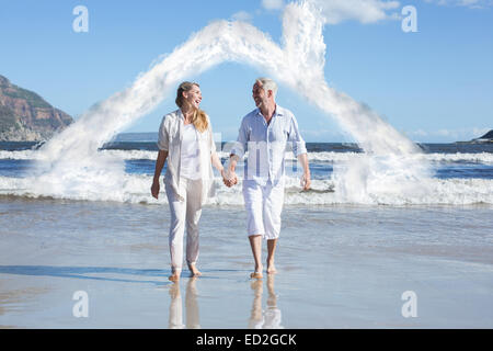 Zusammengesetztes Bild des glücklichen Paares barfuß am Strand Stockfoto