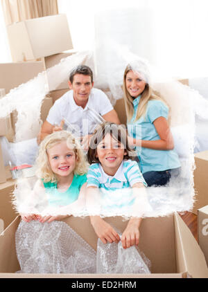 Zusammengesetztes Bild des Lächelns Familie Umzugskartons Stockfoto