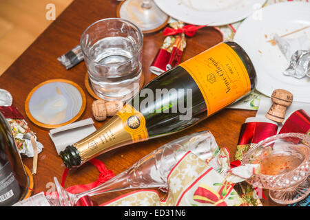 Ablagerungen im Anschluss an eine festliche Jahreszeit Party mit einer leeren Flasche Veuve Clicquot Champagner und anderem Müll Stockfoto