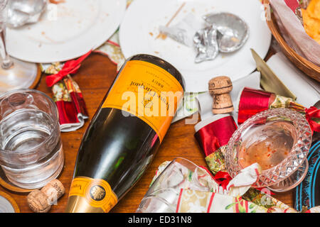 Ablagerungen im Anschluss an eine festliche Jahreszeit Party mit einer leeren Flasche Veuve Clicquot Champagner und anderem Müll Stockfoto