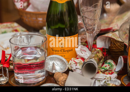 Ablagerungen im Anschluss an eine festliche Jahreszeit Party mit einer leeren Flasche Veuve Clicquot Champagner und anderem Müll Stockfoto