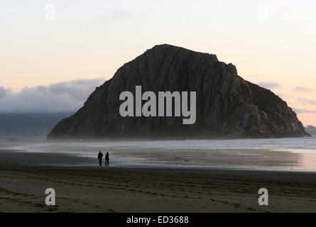 Zwei Personen, die sehr klein sind, schlendern am Strand Stockfoto
