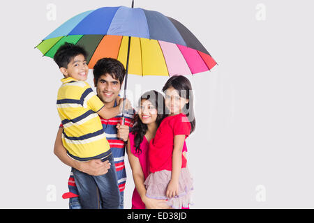 indische Eltern und Kinder Regenschirm Regenschutz Stockfoto