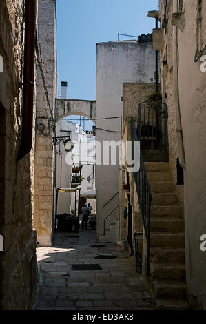 Typische Gasse in den Ländern der Region Apulien (Italien) mit Steinfußboden und weiße Wände. Stockfoto