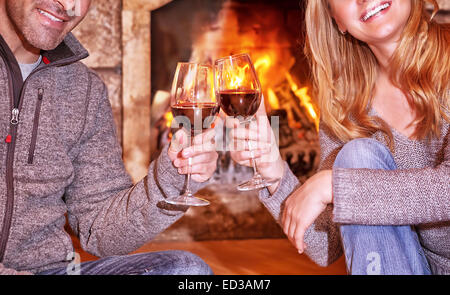 Glückliches junges Paar Kamin sitzen und Wein trinken, genießen Sie romantisches Date, gefeiert Valentines Tag in einem gemütlichen winter Stockfoto