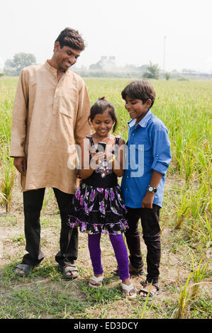 indische ländliche Landwirt und Kind Bauernhof Dialing-Telefon Stockfoto