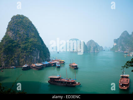 Ein Blick auf die spektakulären Kalkstein Karstformationen erhebt sich über Boote ankern in Halong Bucht, Vietnam.
