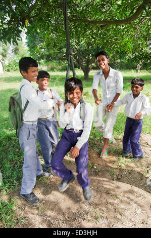 indische ländliche Kinder Schule Schüler Park spielen Reifen Schaukel Stockfoto