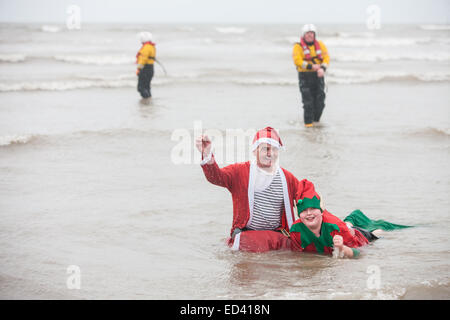 Carmarthenshire, Wales, UK. 26. Dezember 2014. In Pembrey Sands, Cefn Sidan, auf einem sehr kalten, windigen und mit starkem Regen zum 30. Geburtstag der Walross-Dip. Mutige Schwimmer ertragen die Elemente in verschiedenen Fancy Dress Kostüme für einen kurzen Sprung in den eiskalten Gewässern gekleidet. Carmarthenshire, Wales, UK. Bildnachweis: Paul Quayle/Alamy Live-Nachrichten Stockfoto