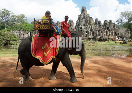 ANGKOR WAT, Kambodscha - 30. Oktober 2014: Touristen ein Elefantenritt auf einem Howdah Stuhl, eine umstrittene und schädliche Praxis. Stockfoto