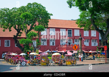 Fahrrad-Rikschas warten auf dem Roten Platz für Touristen vor niederländischen Stadthuys, alte koloniale Rathaus in Malacca Stadt, Malaysia Stockfoto