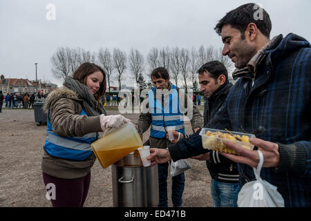 Calais, Frankreich. 26. Dezember 2014. Eine lokale Hilfsorganisation L'Auberge des Migranten warmes Essen für Hunderte von Migranten in Calais zweimal in der Woche zu verteilen. Nach Angaben des UNHCR über 3.000 Migranten leben in und um Calais in Notunterkünften '' "dreimal die Zahl zu Beginn des Jahres. Der Europäische Direktor des UN Flüchtlingshilfswerk (UNHCR) beschrieb die Situation als beschämenden und warnte sterben mehr Menschen in den Flüchtlingslagern in den kommenden Wochen werden wie die Temperaturen sinken. Bildnachweis: Velar Grant/ZUMA Wire/ZUMAPRESS.com/Alamy Live-Nachrichten Stockfoto