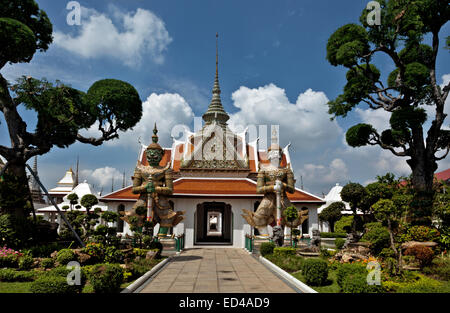 THAILAND - sorgfältig beschnittene Bäume und Büsche und der Sahat Decha (White Stone Giant) und Thotsakan (Green Giant) im Wat Arun. Stockfoto