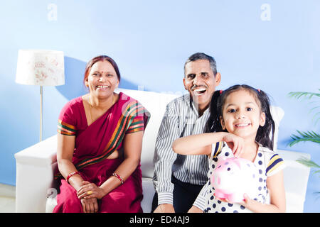 indischer Eltern mit Kind sparen Piggy Bank Stockfoto