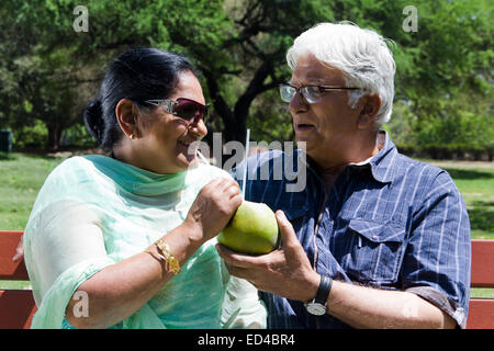 indische alten Ehepaar Park genießen Sie trinken Kokosnuss Stockfoto