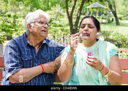 Alten Ehepaar indischen Park Blowing Bubbles Stockfoto