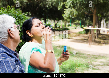 Alten Ehepaar indischen Park Blowing Bubbles Stockfoto