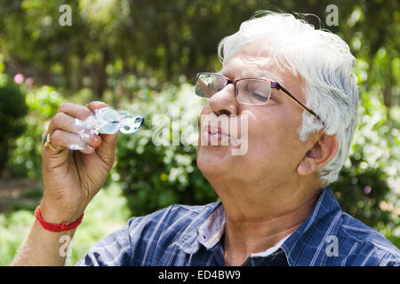 indische Greis Park Blowing Bubbles Stockfoto