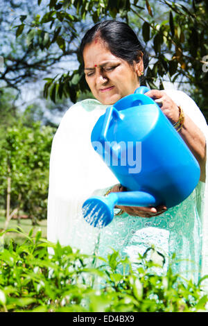 Alten Indianerin Garten Blume gießen Wasser Stockfoto