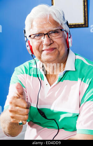 1 indische alte Mann nach Hause Kopfhörer hören von Musik genießen Stockfoto