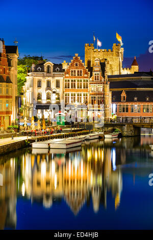 Gent, Belgien. Graslei Wasserkanal mit Reflexion Burg Gravensteen in Nacht, Flandern Stockfoto