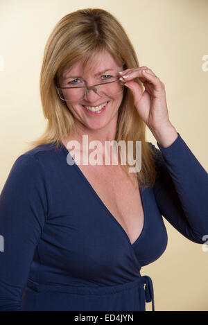 Frau in niedrig geschnitten dunkelblaue Kleid mit einer randlosen Brille Stockfoto