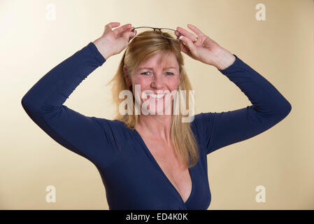 Frau in niedrig geschnitten dunkelblaue Kleid mit einer randlosen Brille Stockfoto