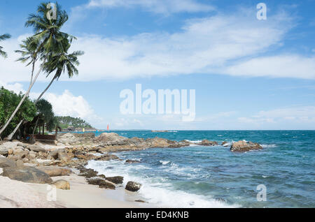 Tropischen Felsenstrand mit Kokosnuss-Palmen, Sandstrand und Meer. Tangalle, südliche Provinz, Sri Lanka, Asien. Stockfoto
