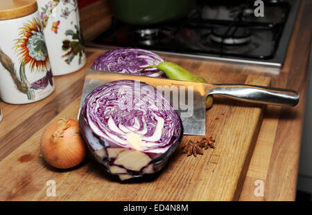 Zutaten für gewürzter Rotkohl gehackt in zwei Hälften mit Birnen eine weiße Zwiebel auf hölzernen Schneidebrett in Küche Stockfoto