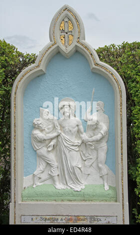 EIRE; MAYO; KLOPFE AN. SCHREIN; RELIEF 10TH STATION OF THE CROSS (Jesus abgestreift von Kleidungsstücken) mit GÄLISCHER Inschrift auf der BASE Stockfoto