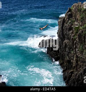 Mann, der in Manarola an der Cinque Terre, Norditalien, von einer felsigen Klippe in den Ozean taucht Stockfoto