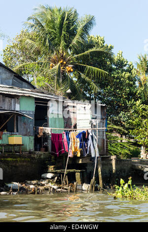 Haus am Fluss Mekong mit einer Wäscheleine voll von Kleidung über das Wasser auf eine Bootstour auf den Kanälen entlang dem Mekong und Phong Dien schwimmenden Markt. Stockfoto