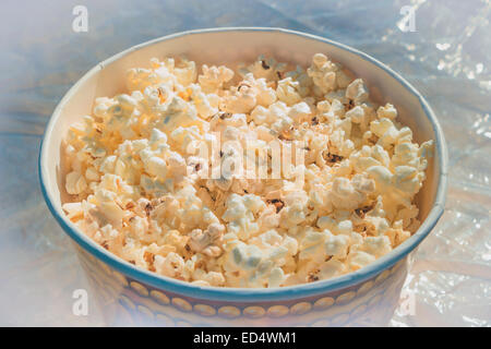 Popcorn in einem großen Glas auf dem Tisch Stockfoto