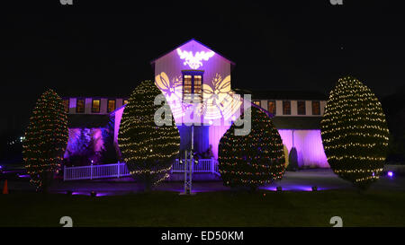 Alten Bethpage, New York, USA. 26. Dezember 2014. Am Abend ist die große Scheune auf dem historischen, rustikale alte Bethpage Village Restaurierung bei Kerzenschein und Weihnachtsschmuck in ein 19. Jahrhundert Urlaubserlebnis für Long Island Besucher verwandelt. Die Fassade des Gebäudes ist mit bunten Gobos festliche Glocken beleuchtet, und immergrüne Bäume mit dekorativen Leuchten aufgereiht sind. Familienspaß inklusive Nachbildungen von 1800 Musik, Urlaub Leben zu Hause und ein traditionelles geschmückter Weihnachtsbaum in der großen Scheune. Candle-Light-Abende sind bis zum 30. Dezember statt. (Kredit-Bild: © Ann Par Stockfoto