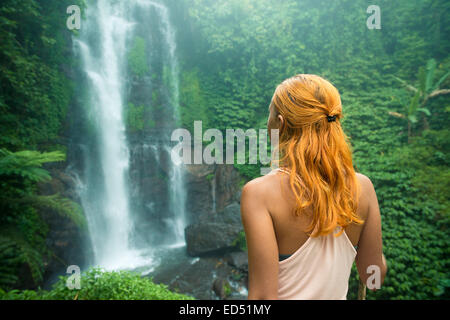 Weibliche Abenteurer am Wasserfall im Dschungel Bali suchen Stockfoto