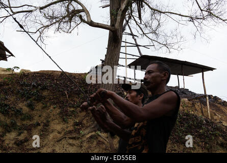 Die Bergleute ziehen Sie mir um Rohöl aus den Vertiefungen manuell in den traditionellen Öl-Bergbau im Unterbezirk Kedewan, Bojonegoro heben Stockfoto